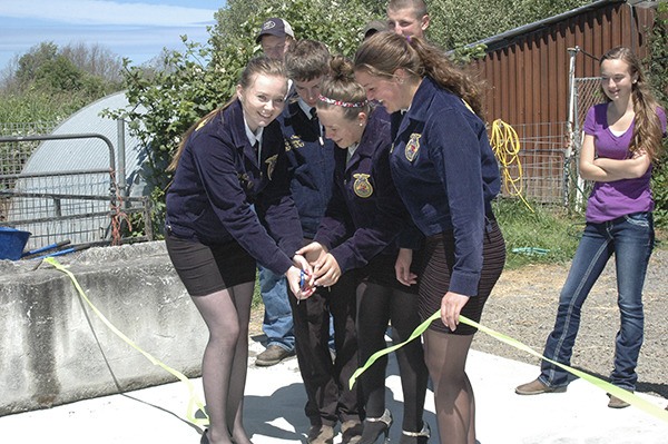 Sequim High School students belonging to the Future Farmers of America program cut the ribbon on their new composting facility June 11. From left