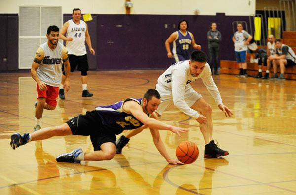 It’s a mad scramble for the ball as Sequim High School senior Skylor Grasseth and SHS English teacher Sean O’Mera vie for control in last weeks Seniors-vs.-Staff basketball game.