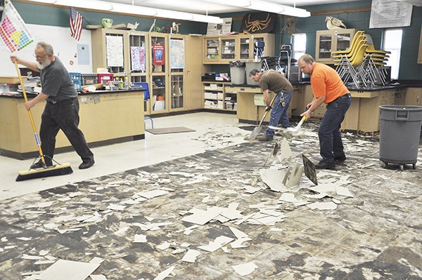 Sequim School District crews work on floors damaged after an old water pipe burst in Sequim High School’s “B” building over the district’s spring break. The building houses science classrooms. Here