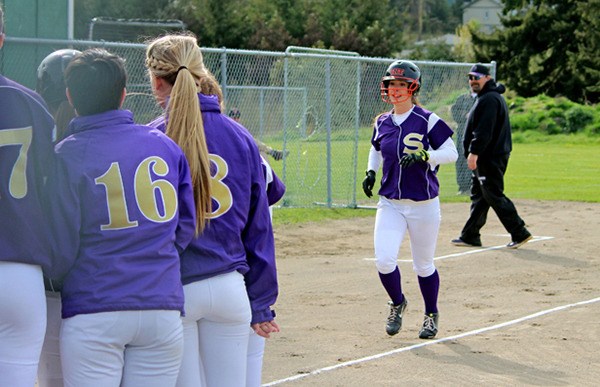 Teammates await MaryLu Clift to congratulate her for hitting a home run as the Wolves beat Port Townsend on April 10.