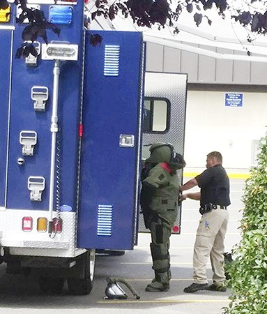 A member of the Washington State Patrol Bomb Squad suits up on July 6 outside the Sequim Post Office to investigate a suspicious package with characteristics similar to a package bomb.