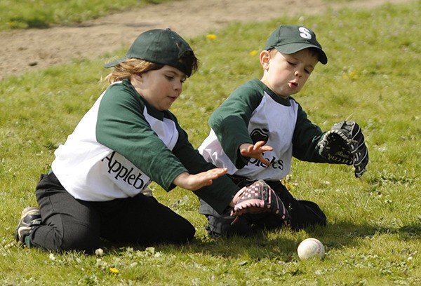 T-ball teammates Mya Ostlund and Henry Sherer of Applebee’s dive to stop a grounder in their first game of the 2016 season.