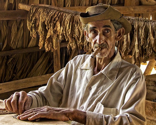 A Cuban man rolls his own tobacco.