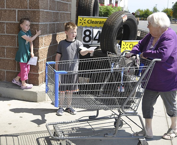 Bekah (5) and Levi (8) Wall hand out lists of needed school supplies at the “Stuff the Bus” event on Aug. 2.