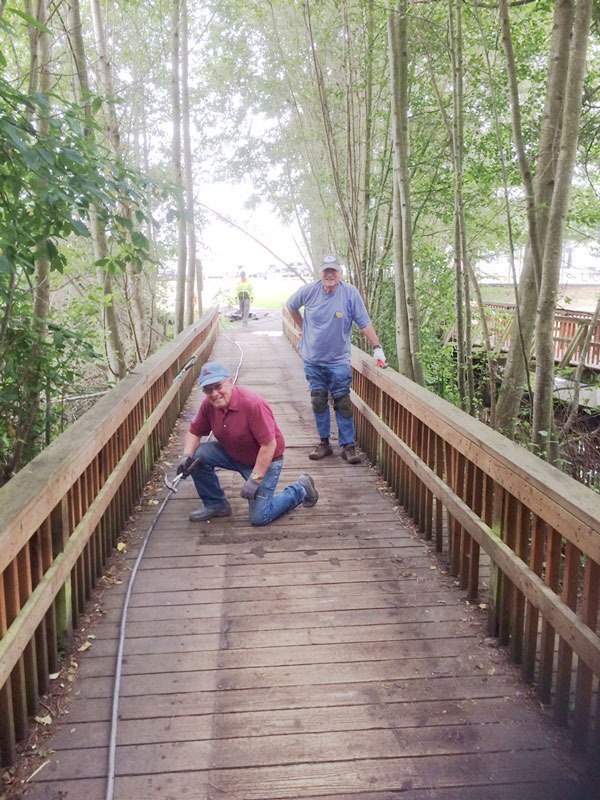 Sequim Sunrise Rotarians work on a bridge at Carrie Blake Park.