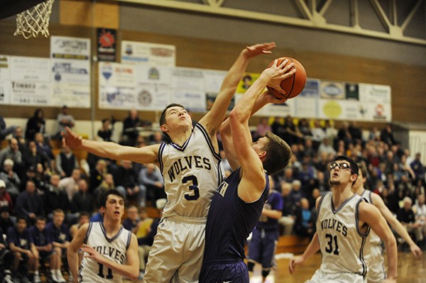 Sequim's Dusty Bates looks to block a shot by North Kitsap's Brooks Ellingsen as Sequim teammates Alex Rutherford (11) and Josh McConnaughey (31) look on. Sequim beat North Kitsap 69-62 on Feb. 3.