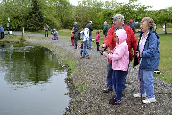 Robert Wilson with the Puget Sound Anglers helps his granddaughter Samantha Box