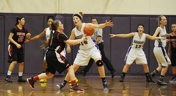 Sequim’s Ella Christiansen (14) and the Wolves defend their basket in the first half of a 55-35 loss to Neah Bay on Dec. 10.