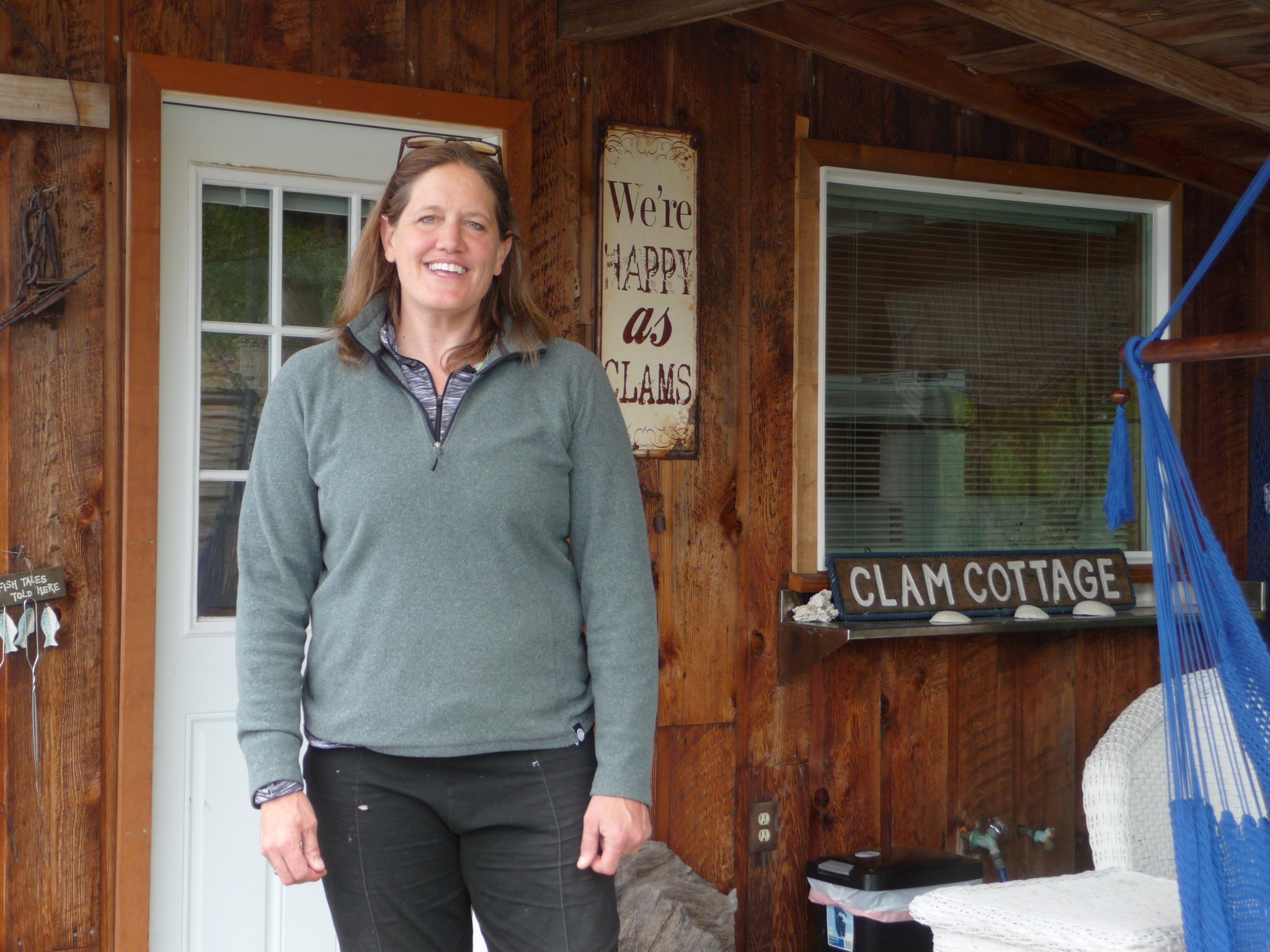 Co-owner Tracie Millet poses on the porch of the Clam Cottage