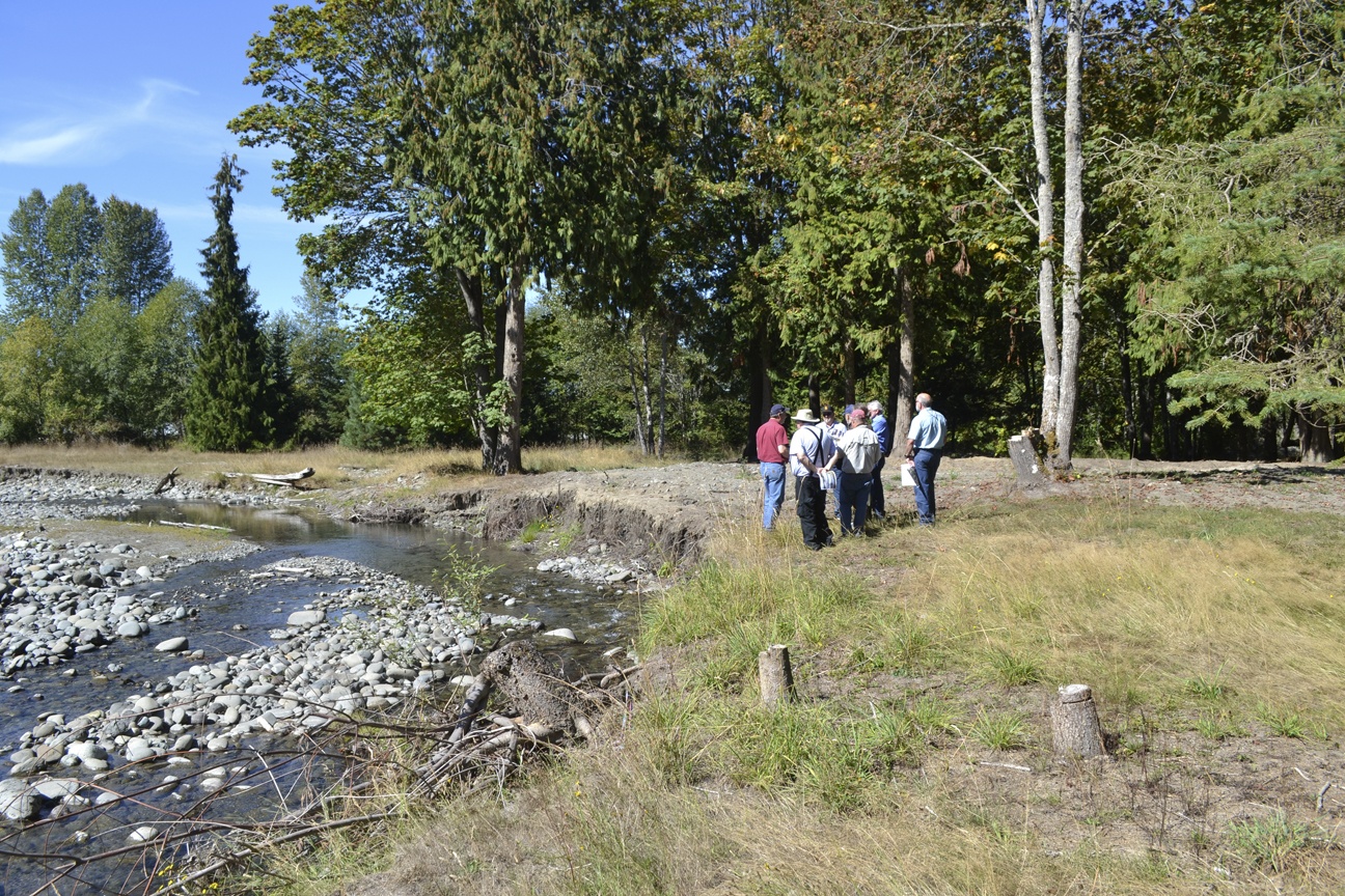 Members of the Dungeness River Management Team stand near the Dungeness River where a home was being threatened by the rising current last winter. Staff with the Jamestown S’Klallam Tribe demoed the home and two others to prevent debris and asbestos from going into the water. Sequim Gazette photo by Matthew Nash