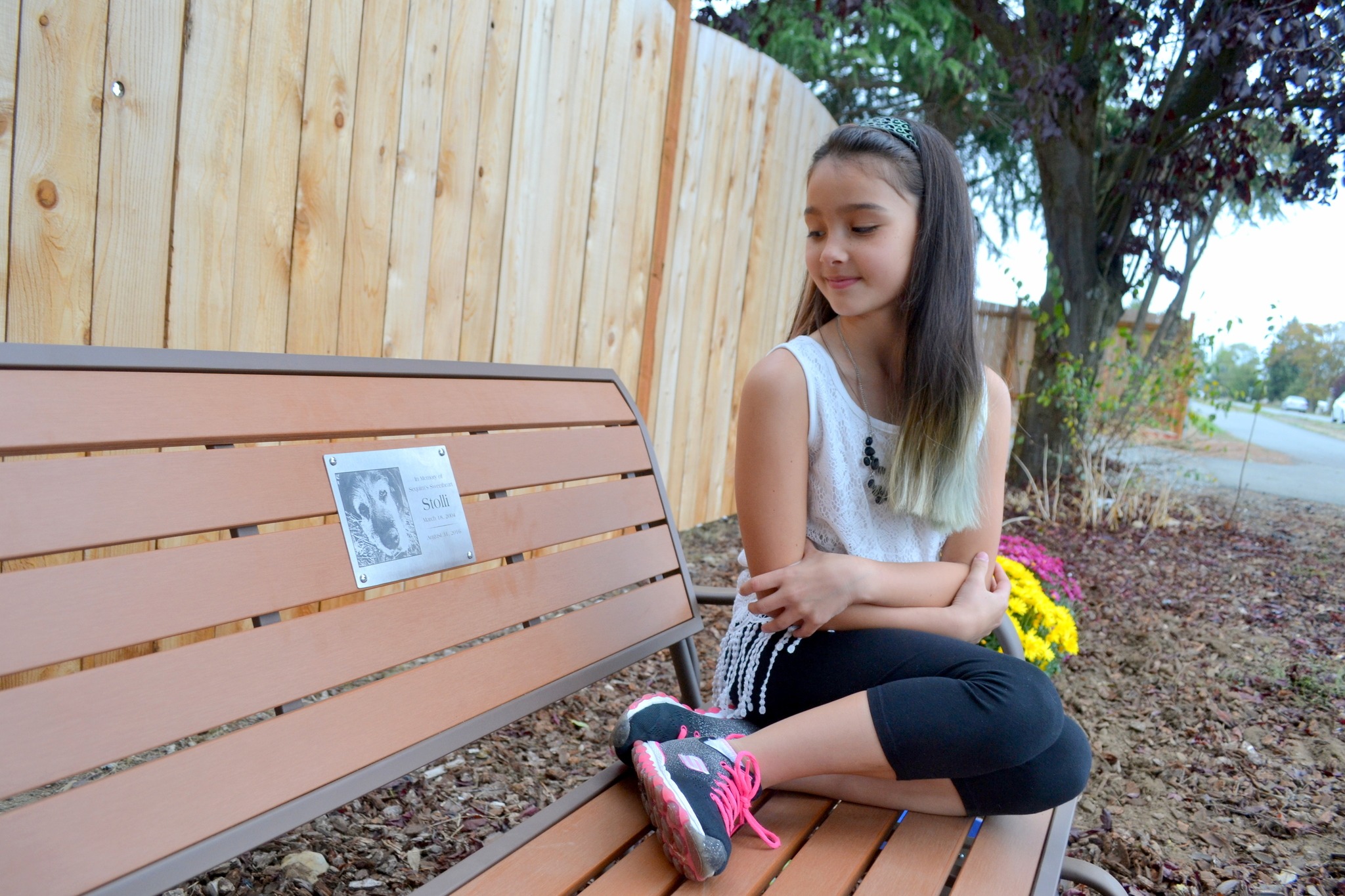 Alabama Cassidy sits on a new bench memorializing her family’s dog Stolli