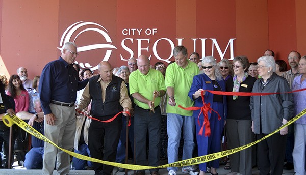 Sequim Deputy Mayor Dennis Smith cuts the ribbon at the opening of the Sequim Civic Center on May 18 next to dignitaries