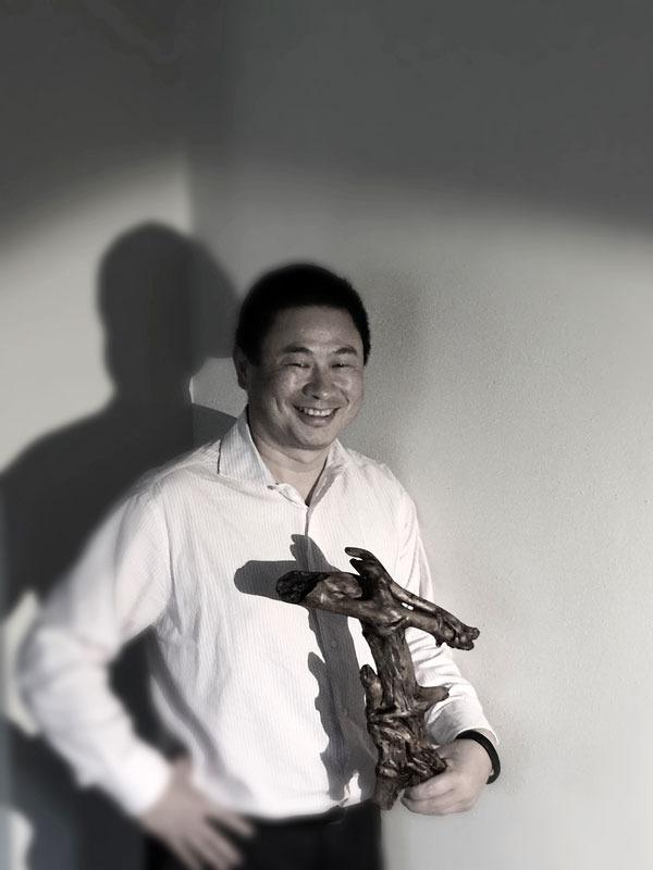 Li Xin stands with his piece “The Dance.” He is the first international member to join the Olympic Driftwood Sculptors and present a piece at their show. Xin said he finds the process relaxing and stimulating at the same time.