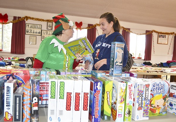 Nancy “Happy the Elf” Rugh gives games advice to Jennifer Hale for her two children at the Toys for Sequim Kids event on Dec. 15.