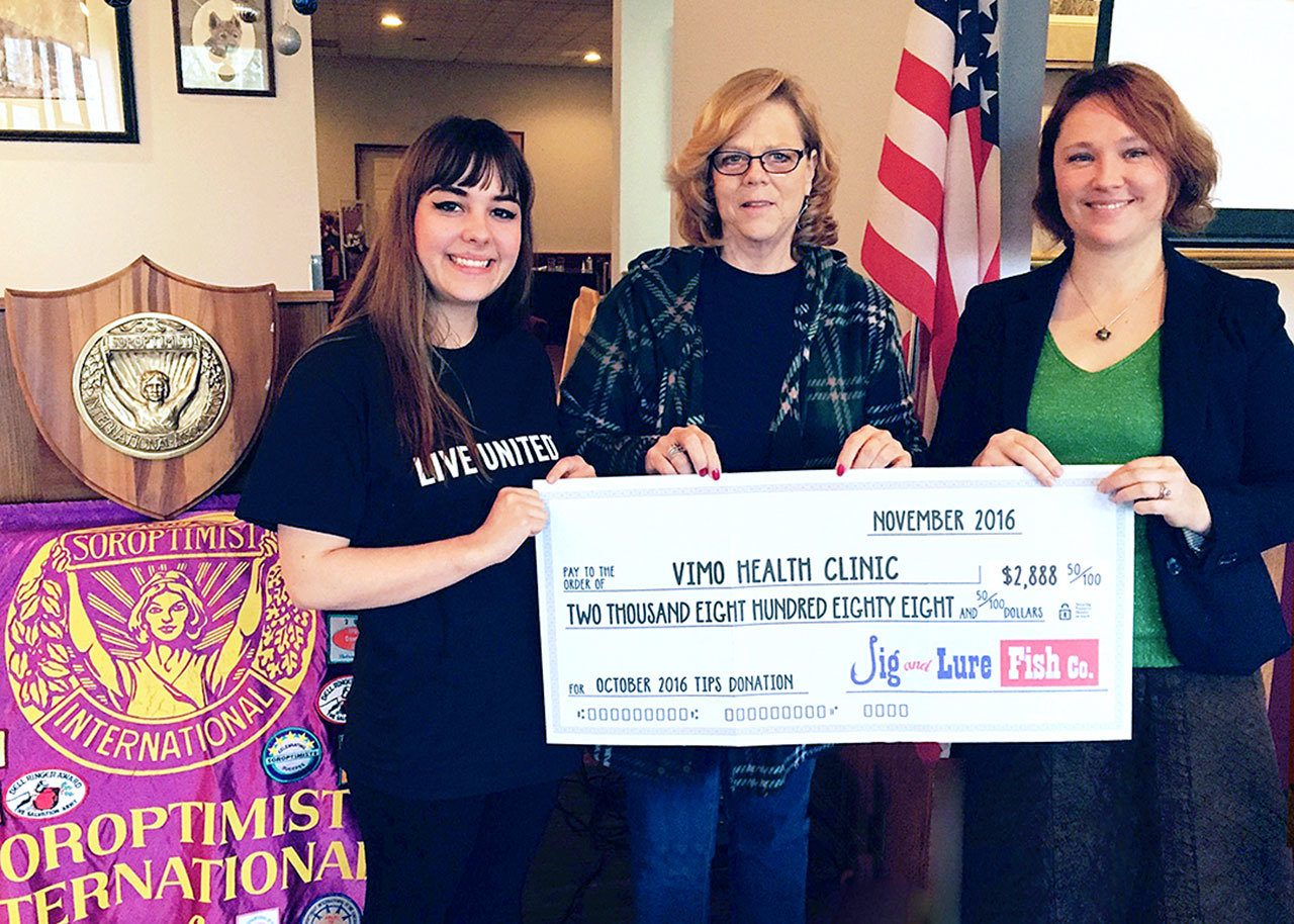 VIMO representative Mary Hogen, center, receives a donation check from Jig and Lure Fish Company employees Sarah Bolen, left, and Christina Fenner at the Soroptomist meeting on Nov. 11. Submitted photo