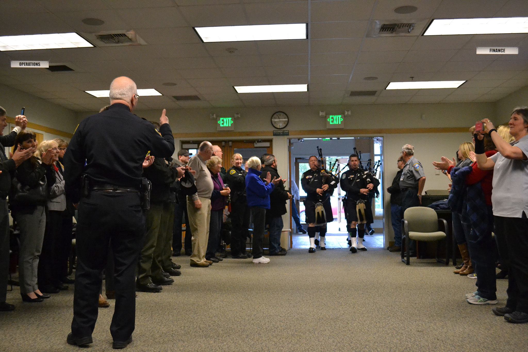 Sequim Police Chief Bill Dickinson gives his approval to the Seattle Police Pipes & Drums group as they enter a ceremony on Dec. 1 in the Sequim Transity Center honoring his 45 years in law enforcement. Sequim Gazette photo by Matthew Nash