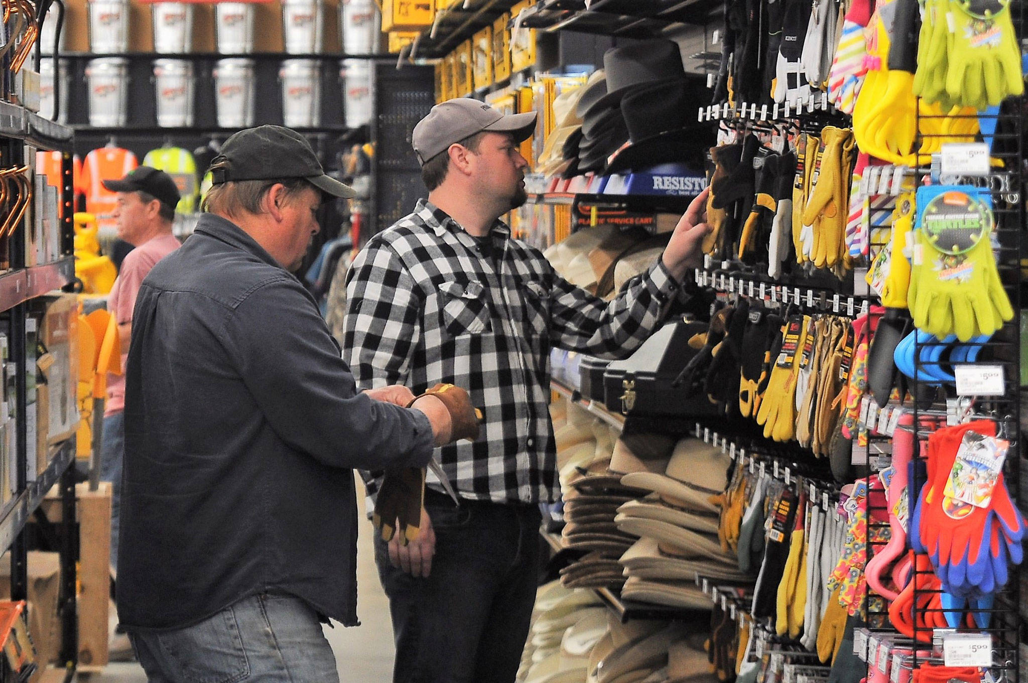 Norm and Travis Stoken of Sequim try on new gloves last week as they visit Coastal Farm & Ranch in Sequim. “I think some of the other stores are going to see some competition,” Travis said. Sequim Gazette photo by Matthew Nash