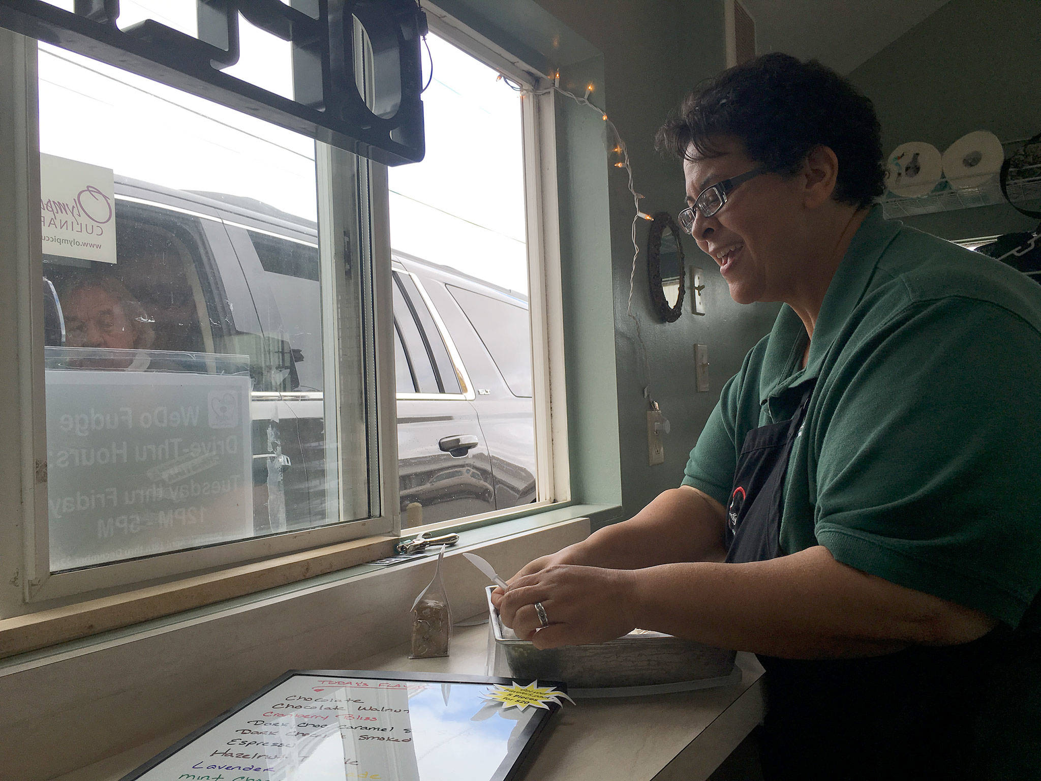 Christina Norman, co-owner of WeDo Fudge in Carlsborg, provides a fudge sample for a customer. She’s also offering prayer now if people ask.