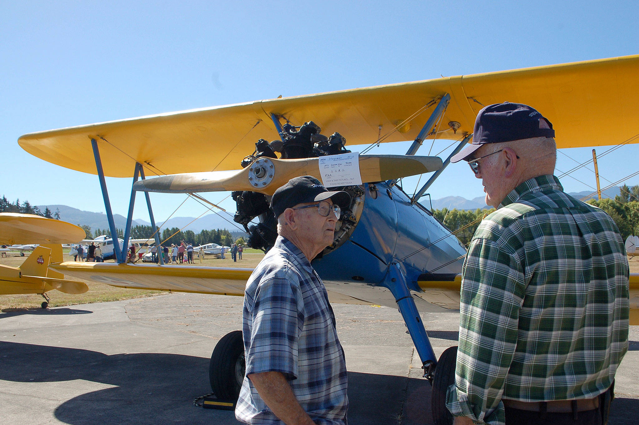 John Denny from south of Seattle, left, chats with Patrick Nolan of the Sequim area about a 1942 PT-17 Stearman restored as a World War II trainer plane owned by the Port Townsend Aero Museum. Sequim Gazette photo by Erin Hawkins