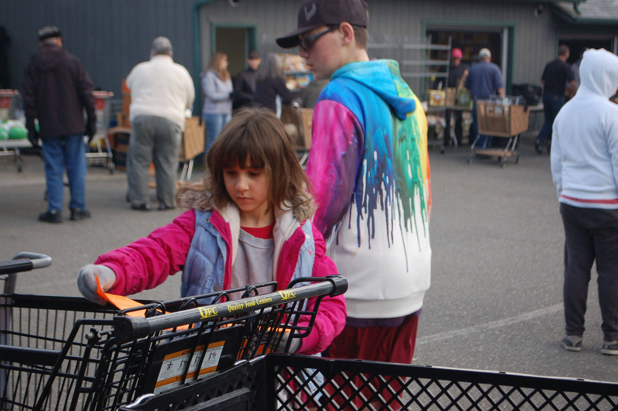 The Sequim Food Bank distributed up to 900 turkey dinners for Thanksgiving from Nov. 17-18 and on Nov. 20 and is preparing to deliver 700 for Christmas. Caitlin Gerdes, 6, puts fliers into grocery baskets filled with food at the Sequim Food Bank on Nov. 17. Sequim Gazette photo by Erin Hawkins