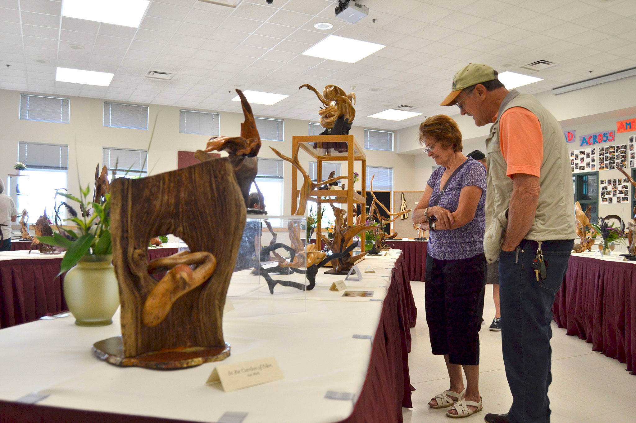 Dale and Joyce Blankenship of Sequim look at work from the Olympic Driftwood Sculptors inside Sequim Middle School at last year’s Lavender Festival Art Show. The event continues for the 10th year July 20-22 in the school. Sequim Gazette file photo by Matthew Nash