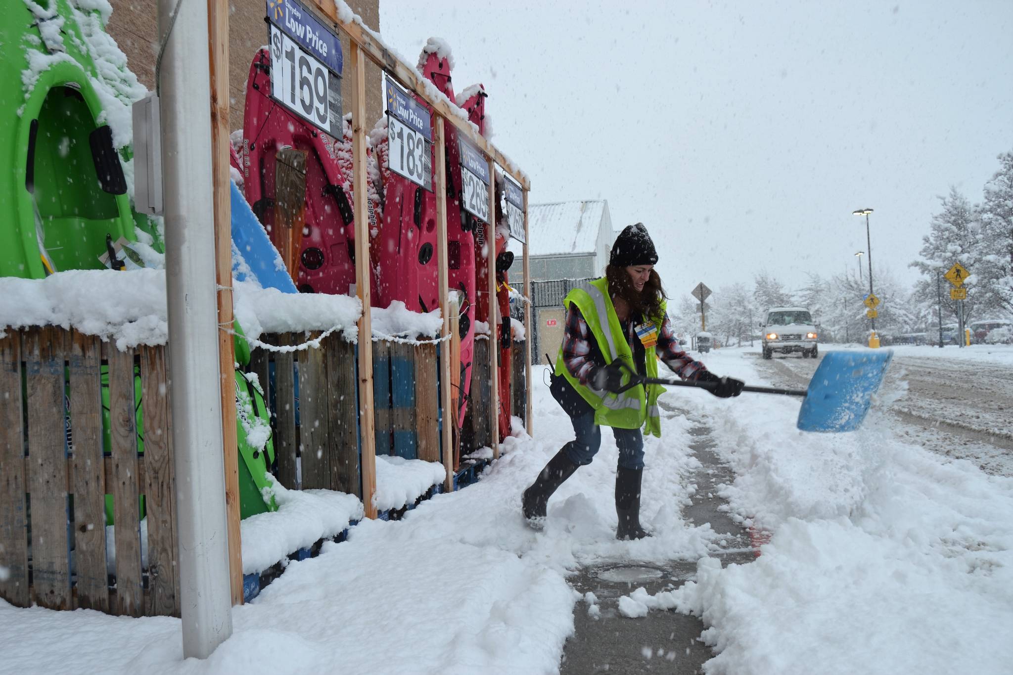 Jeni Madsen, manager of boys and men clothing at Sequim Walmart, helps shovel a pathway on Feb. 8 as snow begin to blanket the area. Sequim Gazette photo by Matthew Nash