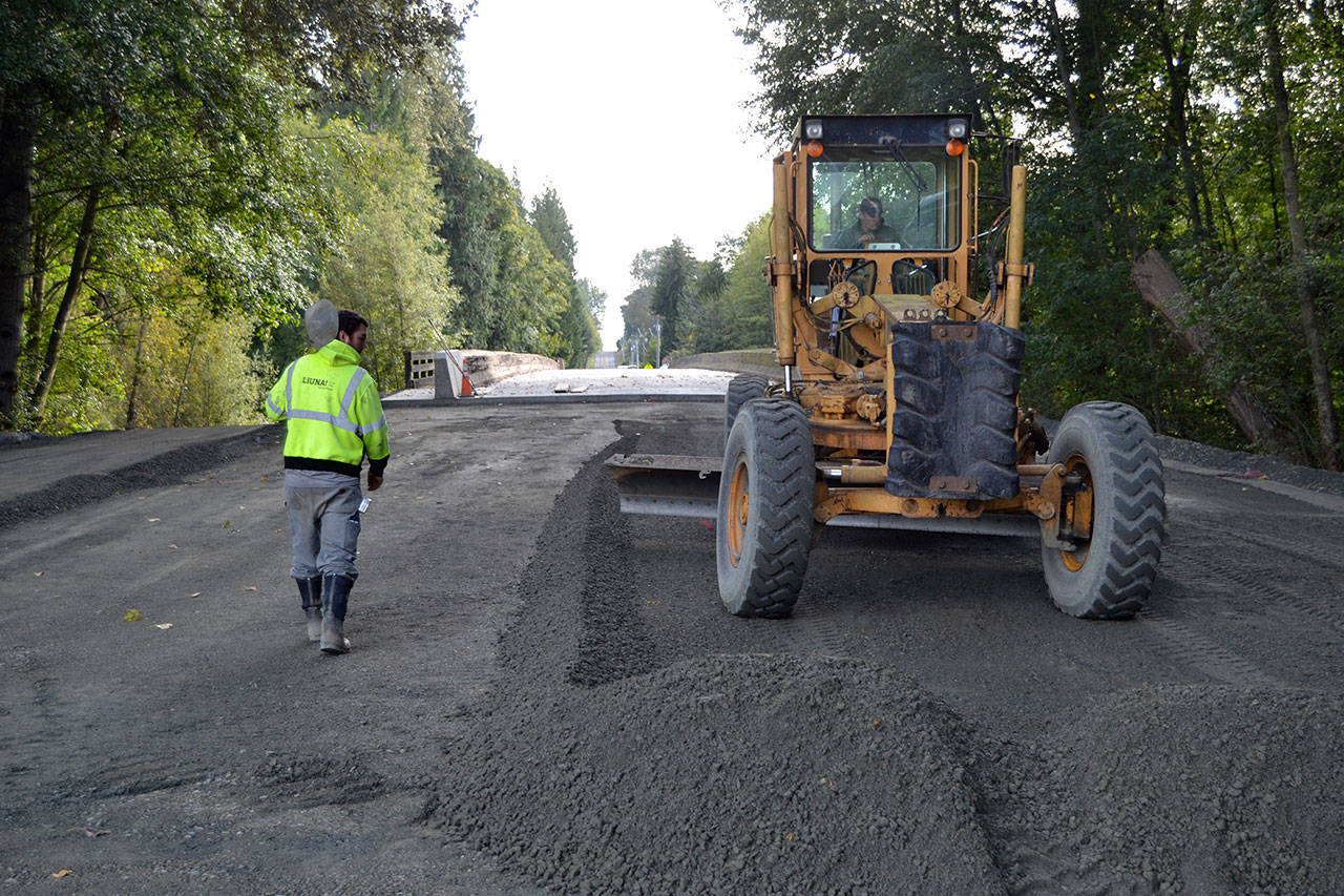 Workers with Bruch & Bruch Construction, Inc. grate gravel on Sept. 19 as they prepare to repave Woodcock Road over Ward Bridge in the next week. Sequim Gazette photos by Matthew Nash