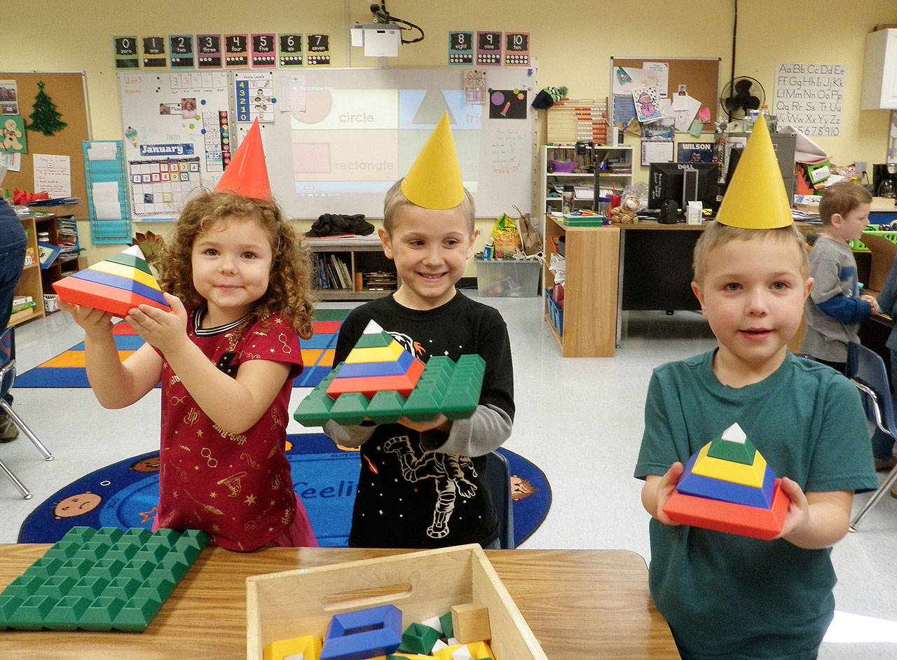 Kindergarteners (from left) Amelia Moose, Atticus Reed and Wesley Priest use interlocking blocks to create 3-D triangles during a shape fair in Lorrie Corder’s classroom at Helen Haller Elementary School.