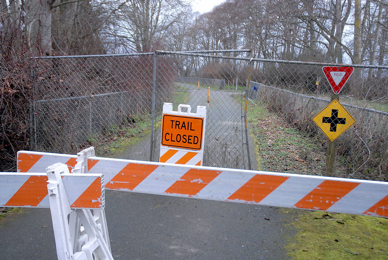 Barricades, construction fencing and a warning sign block a section of the Olympic Discovery Trail near Four Seasons Ranch east of Port Angeles near the site where human remains were discovered near a storm-damaged portion of the trail. Photo by Keith Thorpe/Olympic Peninsula News Group