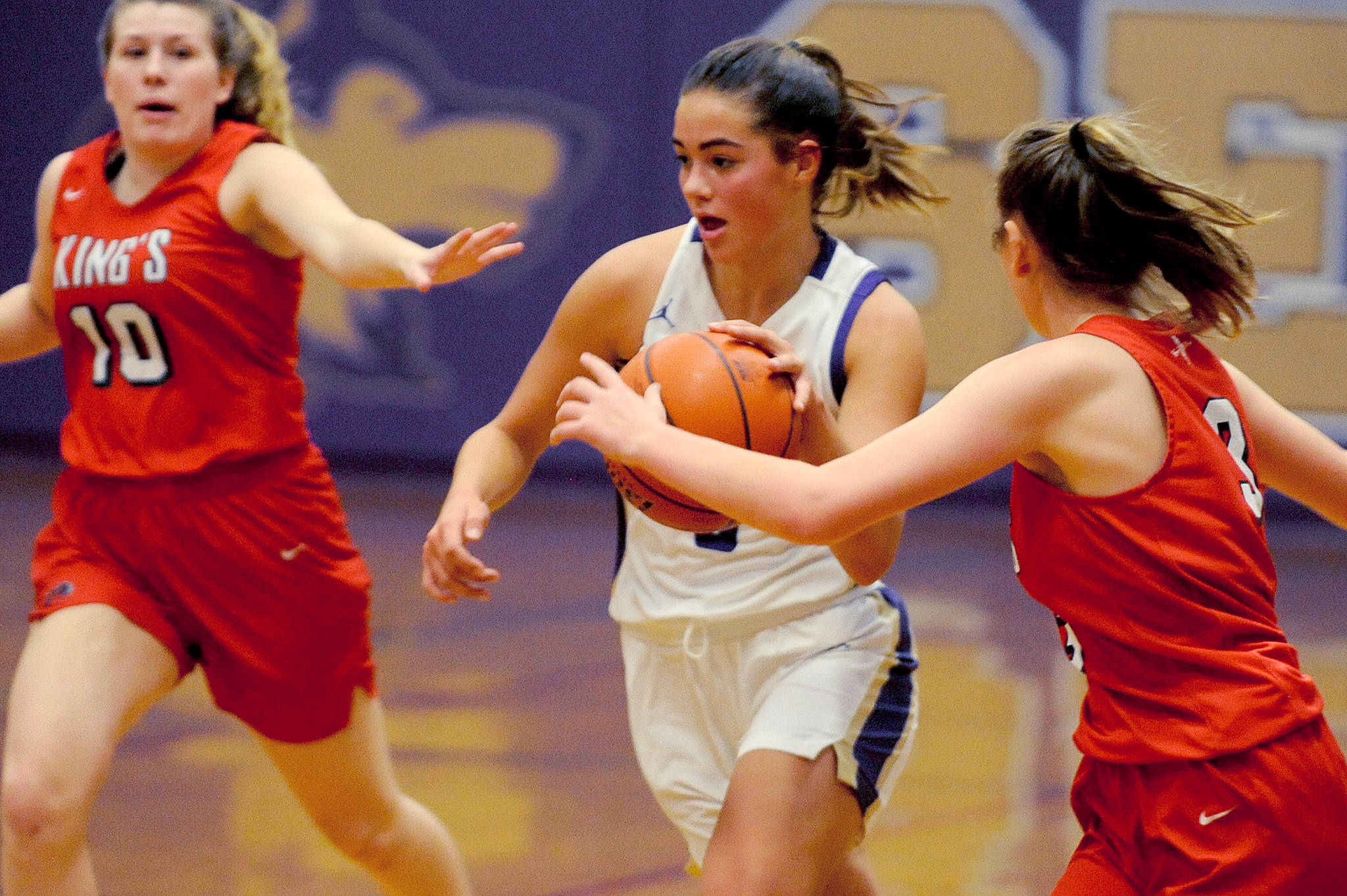 Sequim Wolves post Hope Glasser (center) drives inside against two Kings Knights defenders during the fourth quarter of the Wolves’ 60-52 win over the Knights on Jan. 29. Hope scored 10 points on the night, along with five assists, two steals and a block.