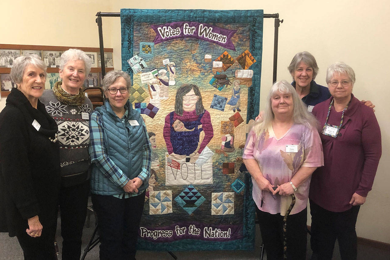 Quilters with the Sunbonnet Sue Quilt Club, from left, Carol Geer, Alanna Levesque, Deni Young, Anna Schenck, Sue Stednick, and Nancy Wilcox, with Norma Herbold not pictured, worked together to create a quilt focusing on women’s right to vote. It’s a collaboration piece with the League of Women Voters to commemorate the 100th anniversary of women’s right to vote. Photo courtesy of Sue Stednick
