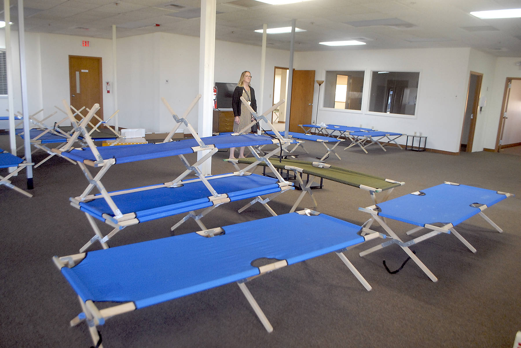 Jess Pankey, an environmental health specialist with Clallam County Heath and Human Services, looks over a room filled with cots last week at the Port of Port Angeles’ 1010 Building near William R. Fairchild International Airport as the building is converted to an isolation shelter for homeless individuals who might be infected with the novel coronavirus. Photo by Keith Thorpe/Olympic Peninsula News Group