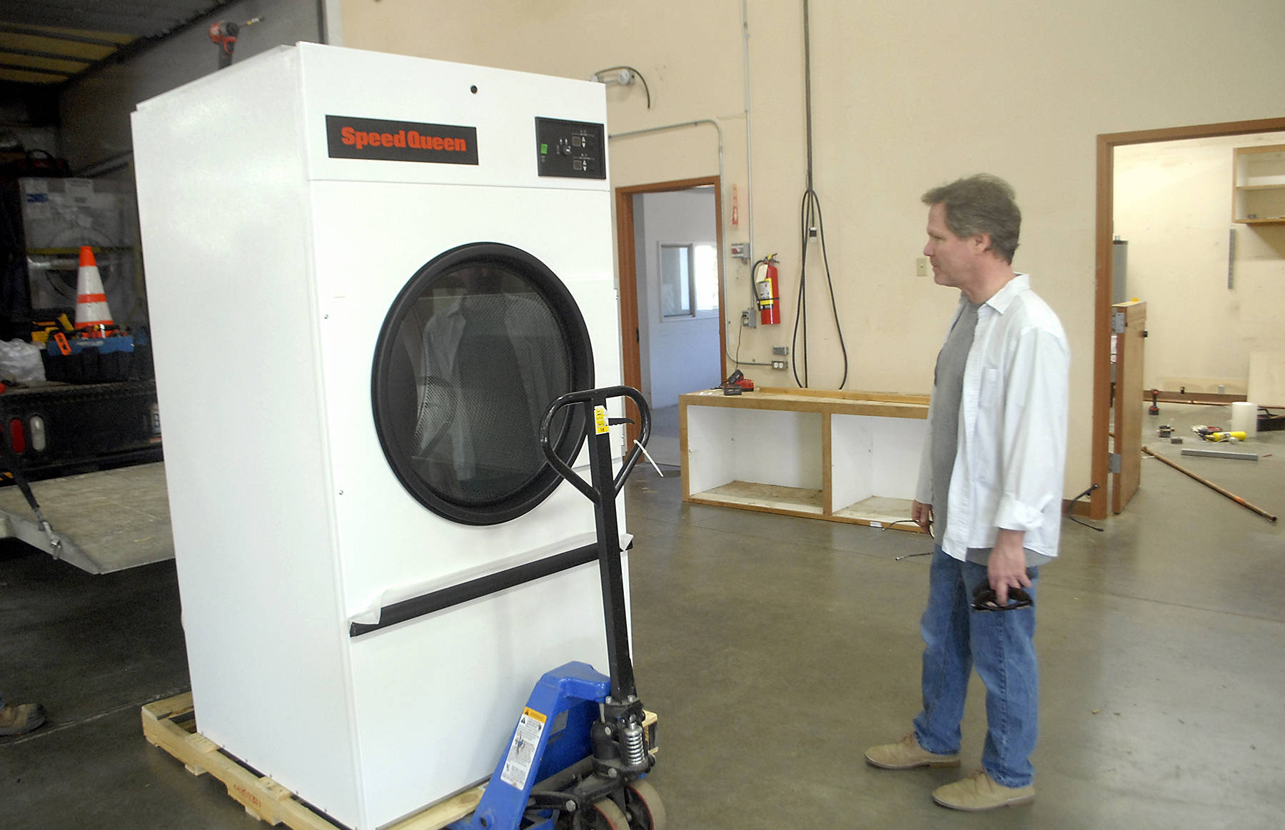 Kevin Lopiccolo, deputy director of Clallam County Health and Human Services, looks over a newly-delivered commercial clothes dryer to be installed last week in the Port of Port Angeles’ 1010 Building near William R. Fairchild International Airport prior to the building’s temporary conversion to an isolation shelter of homeless individuals. Photo by Keith Thorpe/Olympic Peninsula News Group