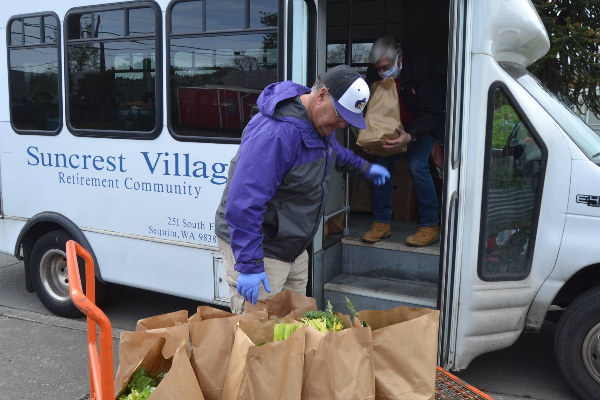 Stephen Rosales, Sequim Food Bank board member, helps Larry Grant, a maintenance worker and driver for Suncrest Village Retirement Community, load up the van for residents of the retirement community on May 1. Food Bank officials say they’ve been distributing food in different ways including deliveries and a drive-thru system in the past month. Sequim Gazette photo by Matthew Nash