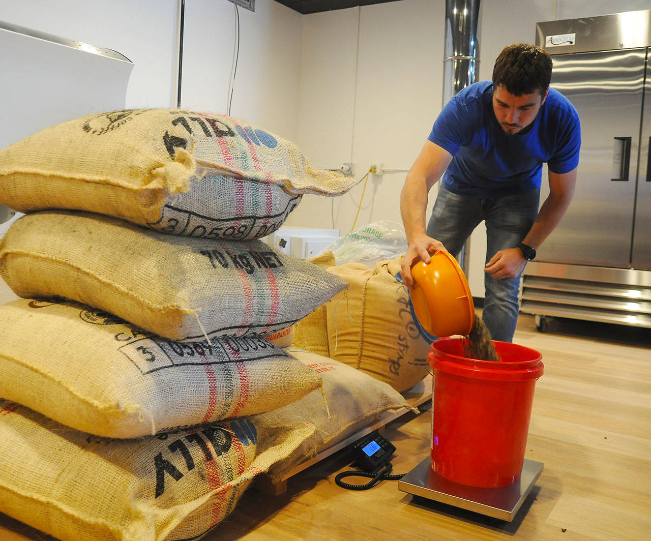 Above: Rod Dirks preps his new business Essence Coffee Roasters, 461 W. Washington St., for its soft opening last week. Left: Newly-hired store manager Ethan Jessee prepares a drink at Essence Coffee Roasters last week. “I was lucky to find hm,” Essence owner Rod Dirks says of Jessee. Sequim Gazette photos by Michael Dashiell