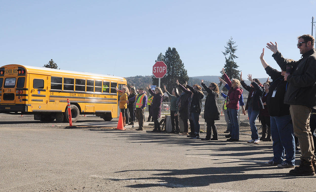 Teachers and staff at Helen Haller Elementary School wave goodbye to students on March 16. Gov. Jay Inslee eventually closed all Washington state schools by executive order. Sequim school leaders are eyeing a phased opening this September. Sequim Gazette file photo by Michael Dashiell