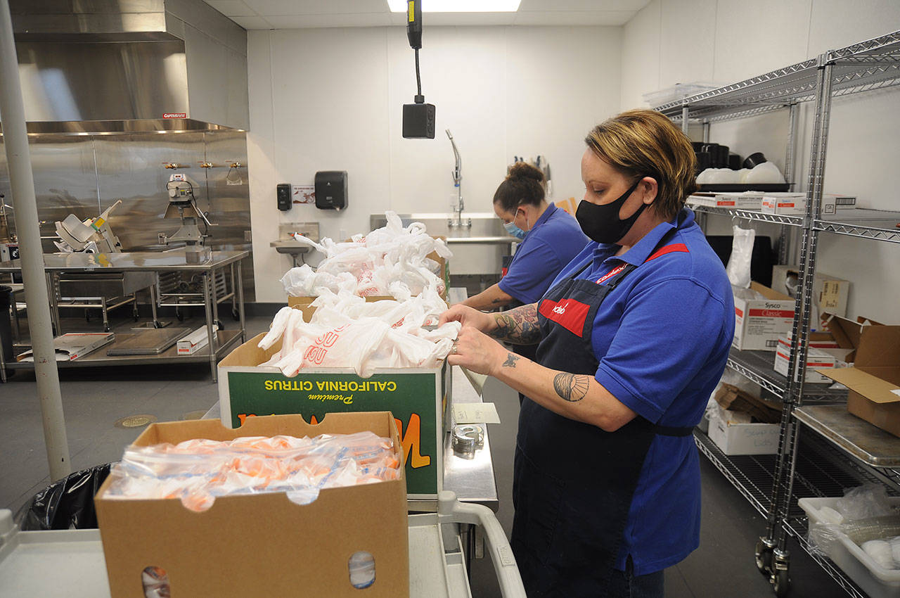 Nikki Hooker, foreground, and Lindsey Kester assemble breakfasts and lunches for Sequim-area students at the Sequim School District’s Central Kitchen on Sept. 15. The district is once again distributing meals throughout the area on Mondays and Wednesdays starting this week. The program is open to all Sequim-area youths of ages 2-18. Sequim Gazette photo by Michael Dashiell