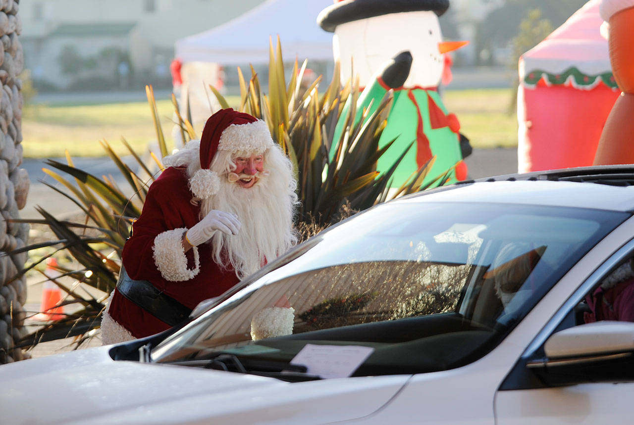 Santa Claus (Mac Macdonald) greets attendees of the “Say Hello to Santa” drive-by event on Dec. 5 at Dungeness Valley Lutheran Church. Hosted by First Teacher and the Parenting Matters Foundation, the event saw youths receiving a goodie bag while spending a socially-distanced visit with Mr. Claus and his group of group of volunteer elves. Sequim Gazette photo by Michael Dashiell