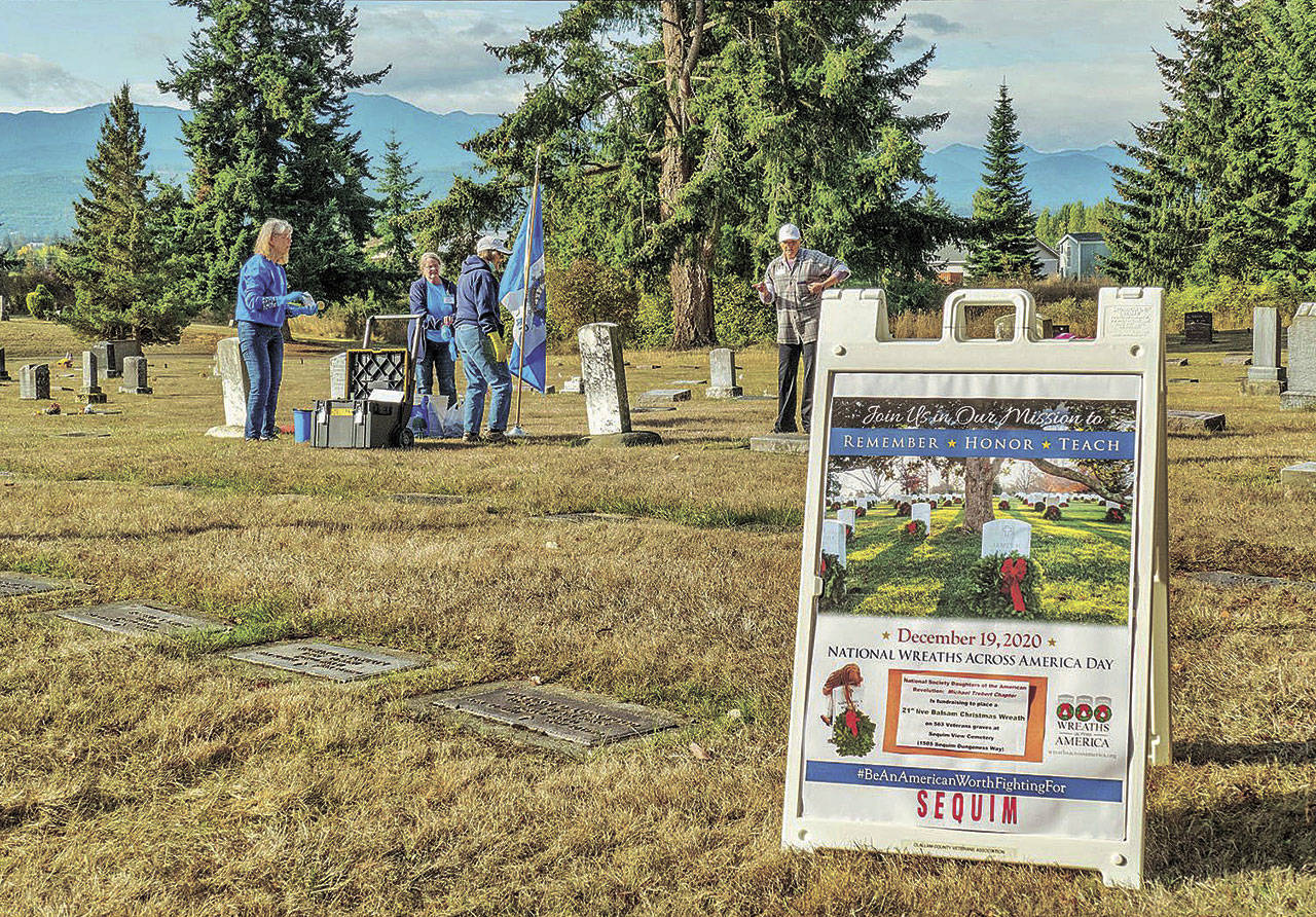 Members of the Michael Trebert Chapter of the Daughters of the American Revolution and Sequim Sunrise Rotary members clean graves at the Sequim View Cemetery in September. The cemetery hosts a Wreaths Across America event on Sept. 19. Photo by Bob Lampert