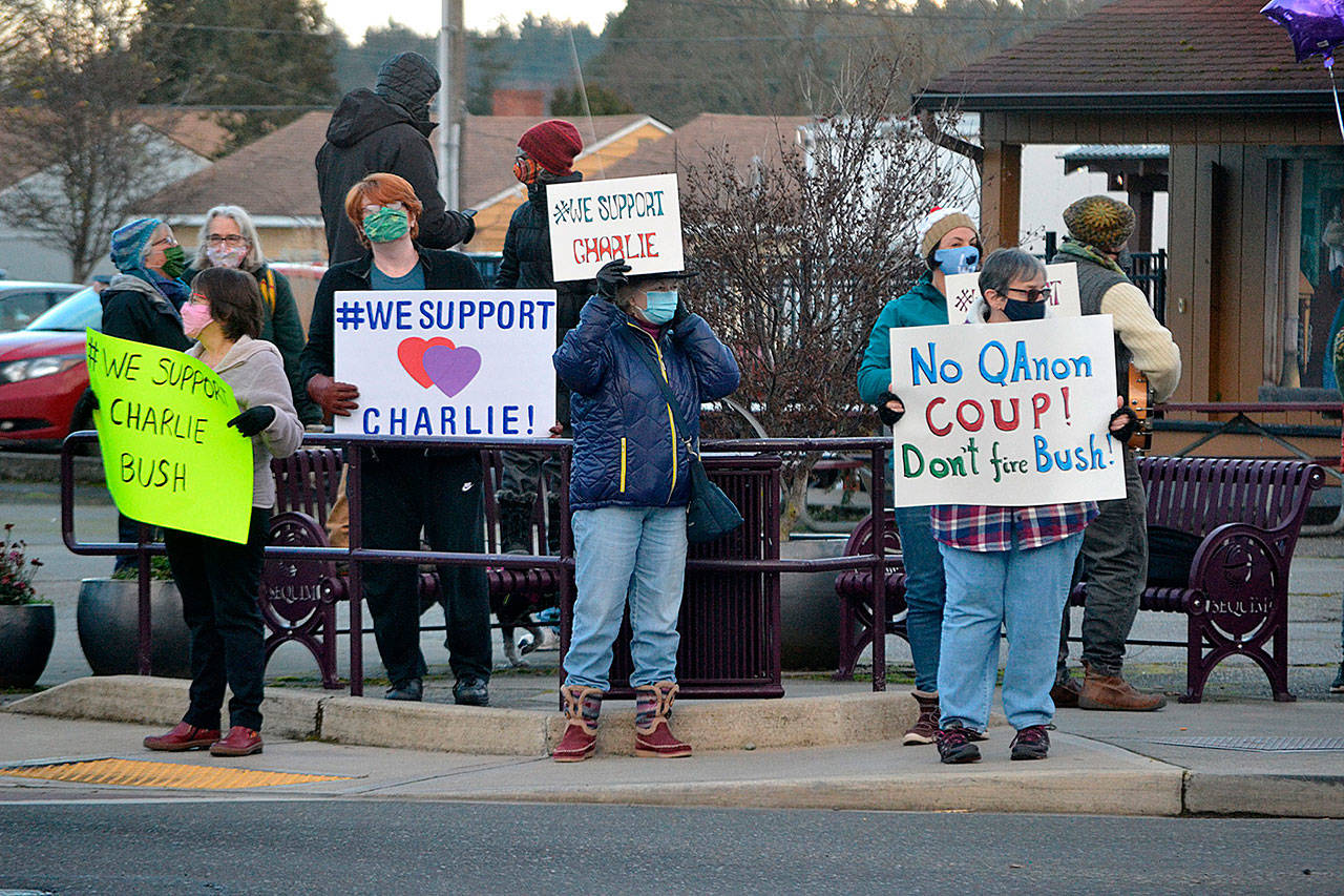 Dozens of people wave signs at the Sequim Avenue/Washington Street intersection Monday in support of Sequim city manager Charlie Bush. Sequim Gazette photo by Matthew Nash