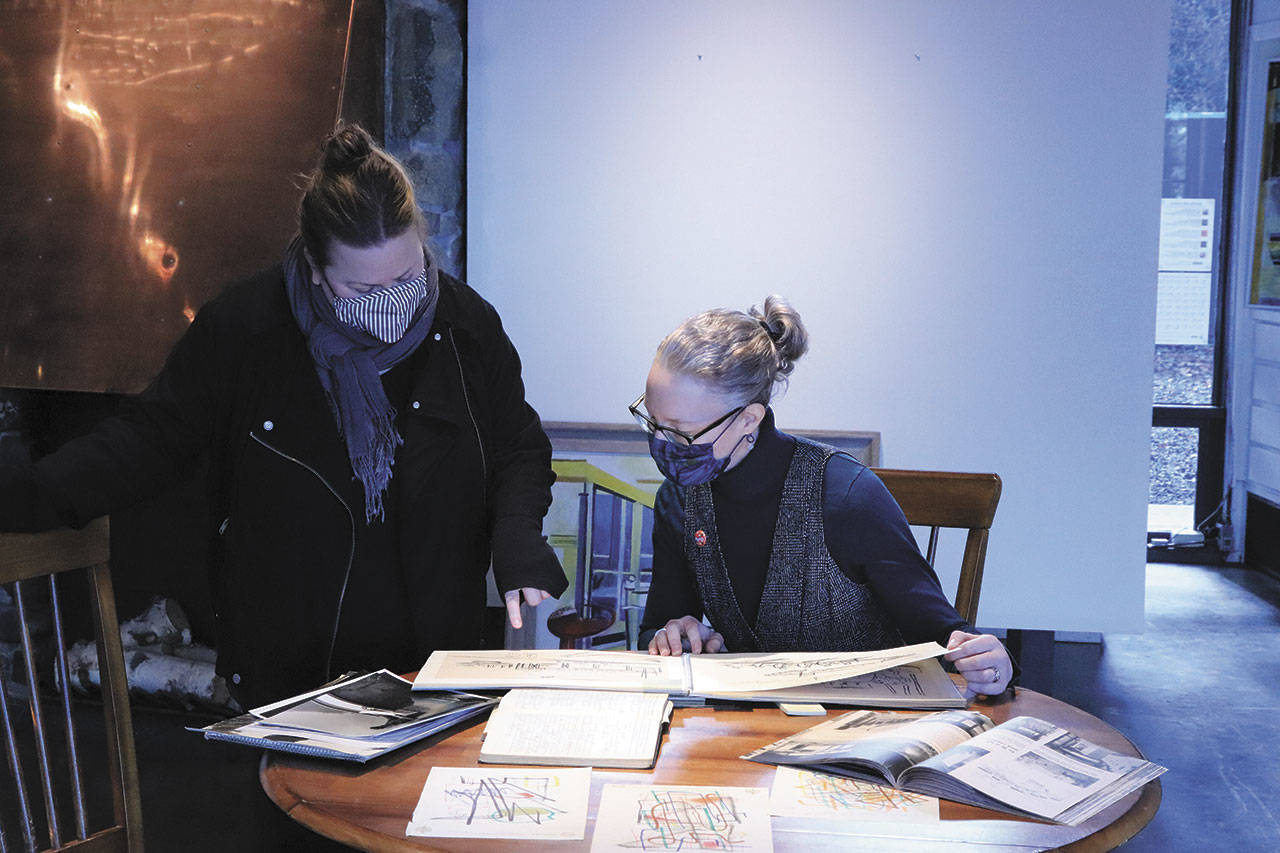 “Creating a Scene” exhibit curators Amy McIntyre, left, and Sarah Jane review Esther Webster’s historic sketchbooks in preparation for the upcoming exhibit. Photo by Kyle LeMaire-Bartholick