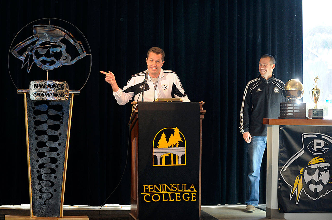 Peninsula College men’s soccer coach Andrew Chapman, left, and Peninsula women’s coach Kanyon Anderson help host the unveiling of a Pirate-themed sculpture following the NWAACC’s first dual back-to-back championship teams in November 2013. Sequim Gazette file photo by Michael Dashiell