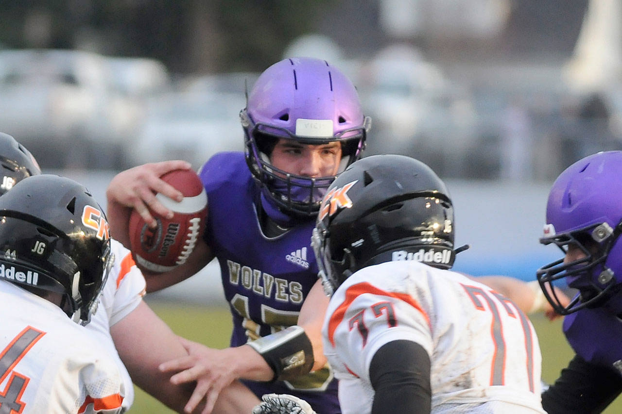 Sequim quarterback Taig Wiker looks for running room in a match-up with Central Kitsap on March 18. New state guidelines allow student-athletes to compete without masks for outdoor fall sports of any contact level, though they are recommended in settings where unvaccinated athletes, coaches, athletic trainers and/or support personnel are in close proximity. Sequim Gazette file photo by Michael Dashiell