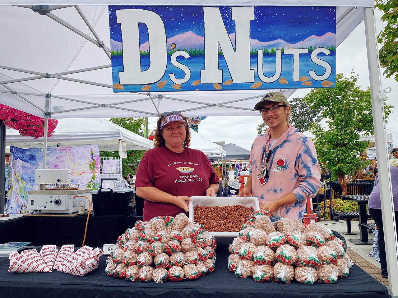 D’s Nuts co-owners Teresa Bentley and Josiah Shearing welcome visitors and regulars to the Sequim Farmers and Artisans Market in downtown Sequim. Photo by Emma Jane “EJ” Garcia