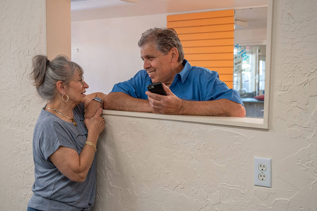 Paula and Joe Fazio exchange glances as they reminisce about 39 years at their combined beauty salon/barber shop on West Washington Street. Sequim Gazette photo by Emily Matthiessen