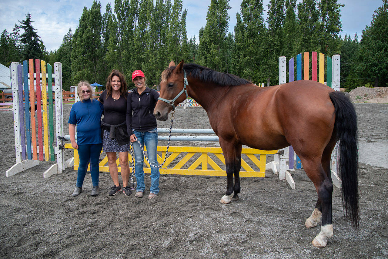 Shay Lucier, Martha Vaughan and Shelby Vaughn stand with Cassie the hourseat Fox-Bell Farms, Port Angeles, during a student show day. Lucier, referred to as “Shelby’s oldest student” by a number of attendees, has been learning conscientious horse care with Shelby since before Shelby bought the farm. Sequim Gazette photo by Emily Matthiessen