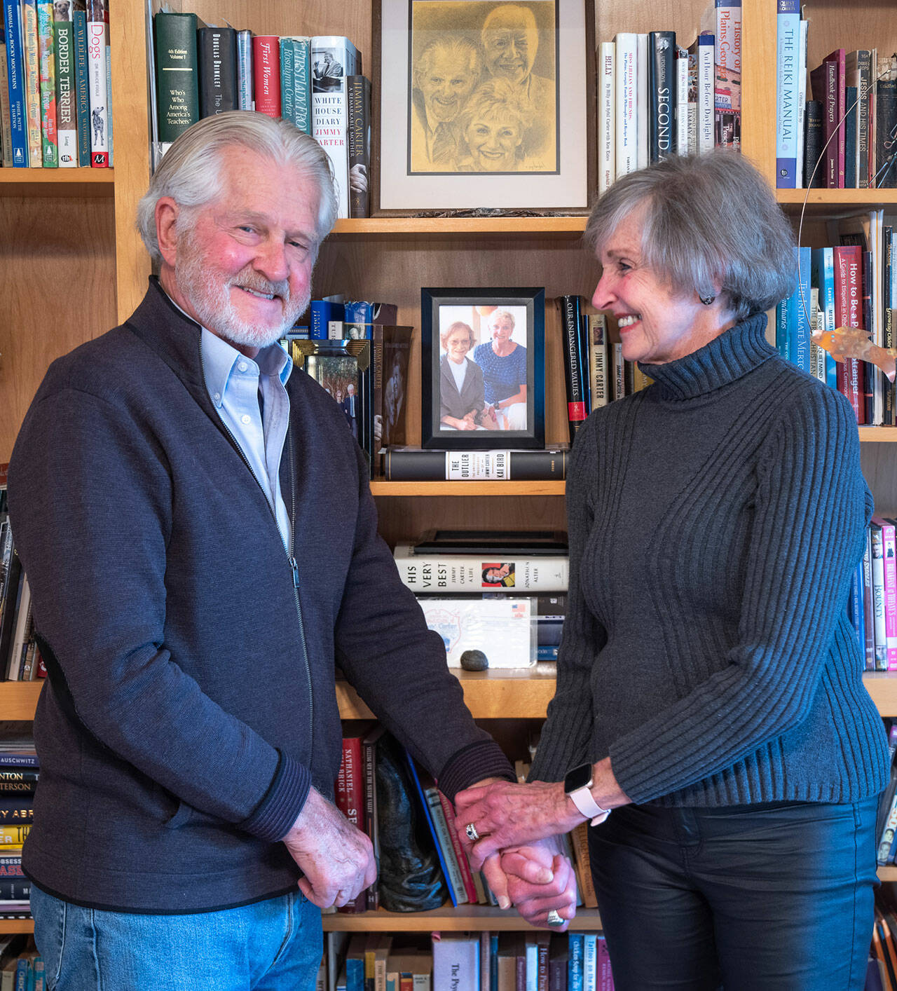 Jim Dries and Carol Swarbrick Dries stand before a bookshelf of Carter memorabilia and books in Sequim. The husband/wife team wrote a two-act one-woman play about Lillian Carter, President Carter’s “remarkable” mother which has evolved into a docudrama released this year, directed by Vivian Winther, with the blessing of the former President. Interviews with Tommy LaSorda, Sam Donaldson, President Carter and Rosalyn Carter are complemented by performances by Swarbrick Dries filmed in Plains, Georgia, the President’s birthplace and hub of humanitarian activity. Sequim Gazette photo by Emily Matthiessen