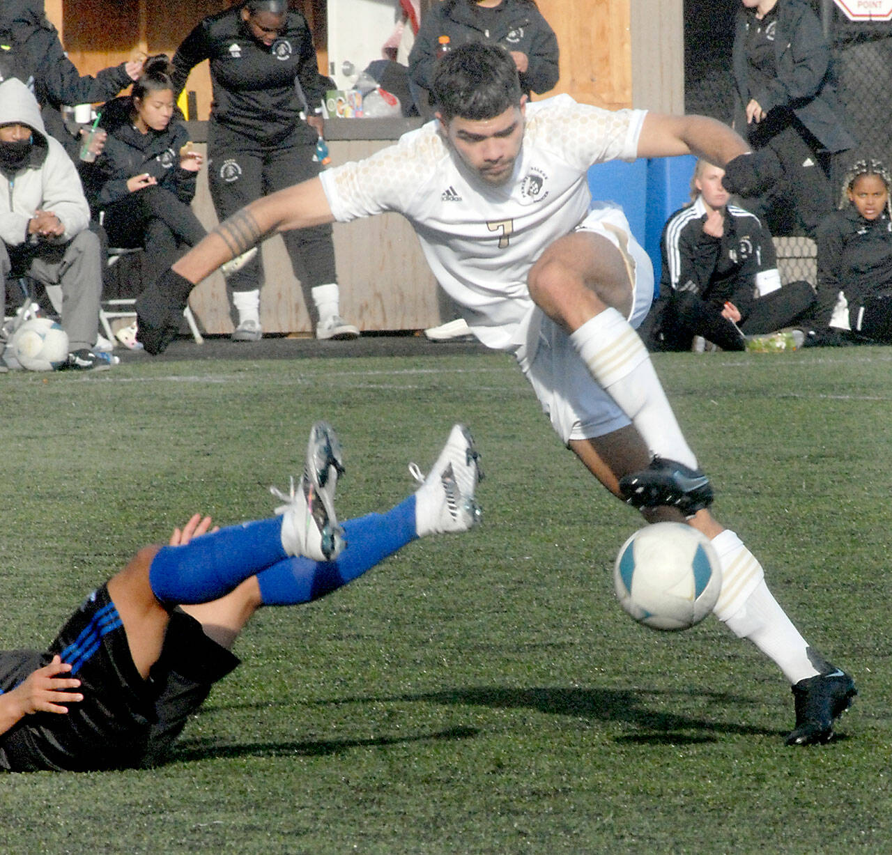 Peninsula’s Jonathan DeMotta barrels over Rogue’s Jose Gallegos on Nov. 6 at Wally Sigmar field in Port Angeles. Photo by Keith Thorpe/Olympic Peninsula News Group