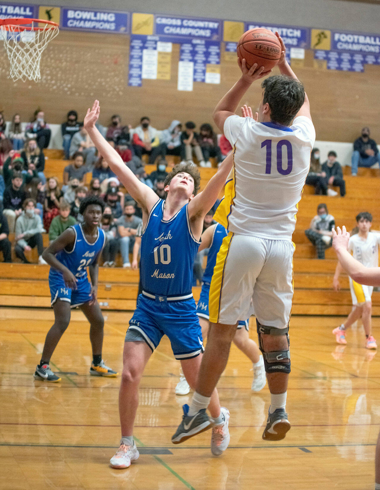 Top: Sequim’s Isaiah Moore, right, drives in for a basket in the Wolves’ 61-50 win over North Mason on Dec. 16. Moore and Keenan Green led the team with 15 points apiece. Bottom: Sequim’s Pryce Glasser, right, puts up a shot over North Mason’s Nick Minaker. Sequim Gazette photos by Emily Matthiessen