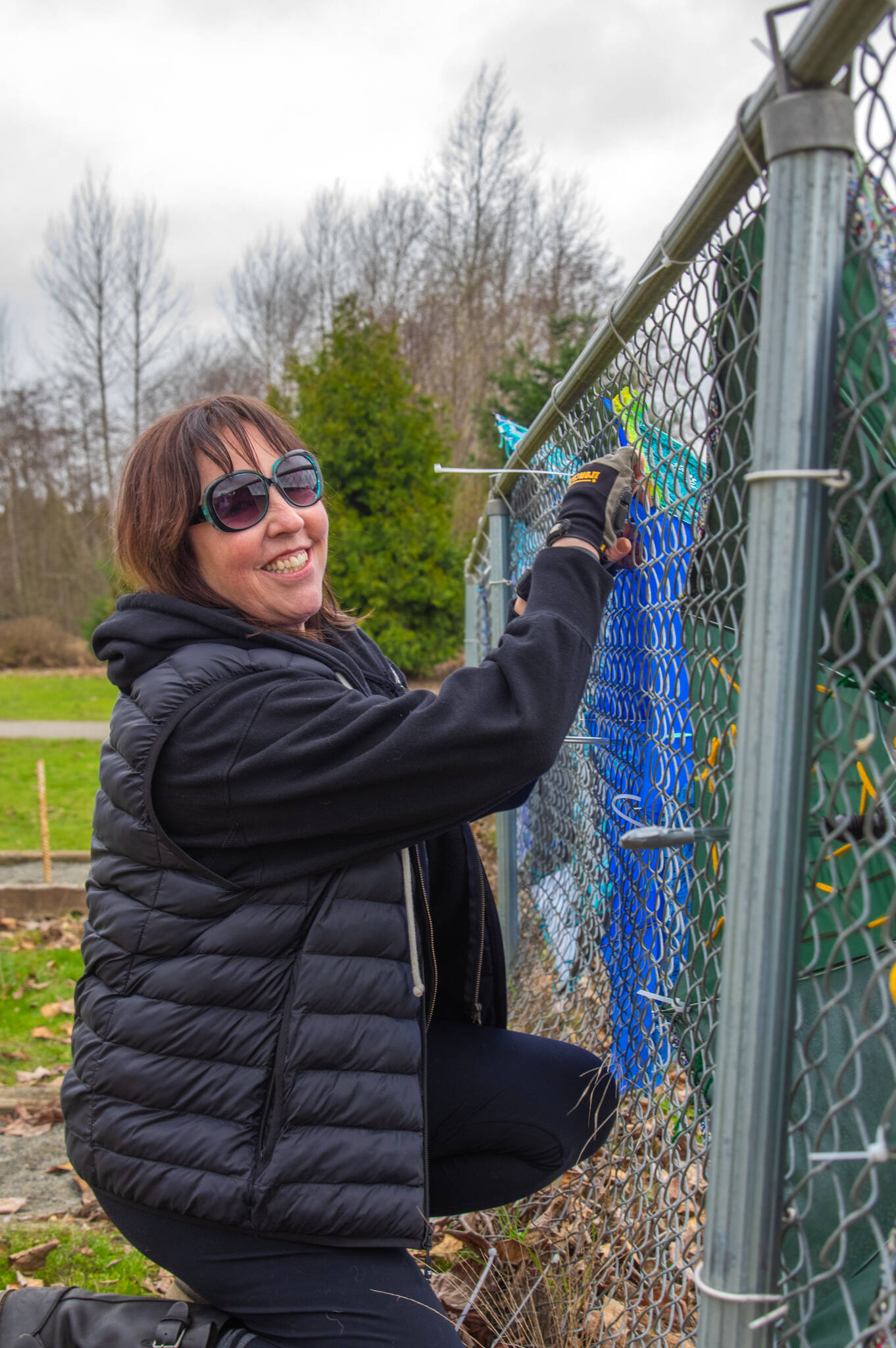 Brigitte Schlemmer of Sequim hangs a “Flumbro:” an umbrella repurposed with materials like yarn and buttons in Carrie Blake City Park. Schlemmer encourages other people to submit their imperfect art to Sequim City’s Art Commissions “Art All Over - The Art Show Without Walls” via a link at sequimwa.gov/1008/Art-All-Over—-The-Art-Show-Without-Wall. Submissions will be accepted for months in the hope that more people will submit their art for hanging in Sequim city parks. Sequim Gazette photo by Emily Matthiessen